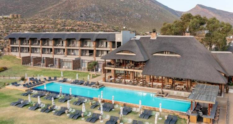 Vista aérea de un complejo de cabañas con piscina al aire libre.