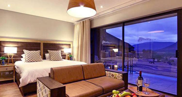 Una habitación de hotel de lujo con vista a las montañas al atardecer.