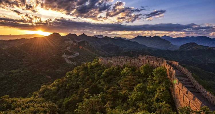 Great Wall of China at sunset with dramatic clouds.