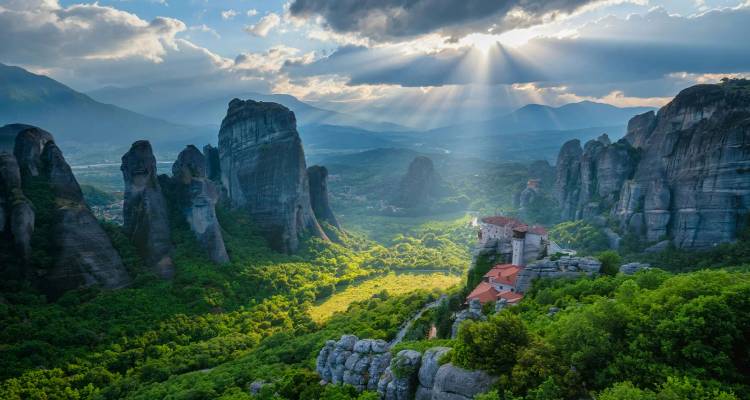 Les rayons de soleil spectaculaires percent les nuages au-dessus des imposants piliers rocheux et des monastères de Météore.