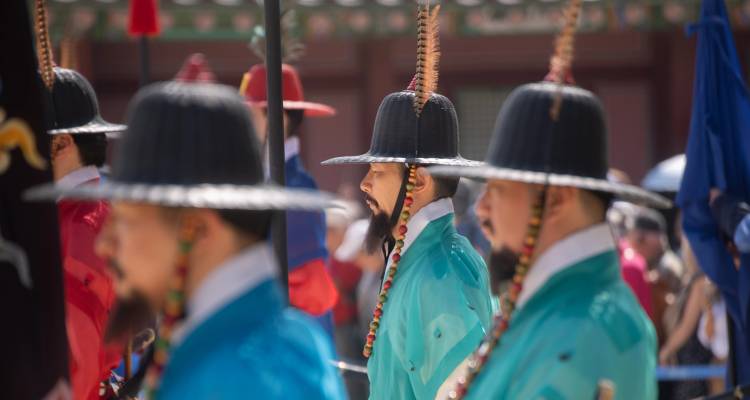 Gardes du palais coréen traditionnel en robes colorées lors d'une procession cérémonielle.