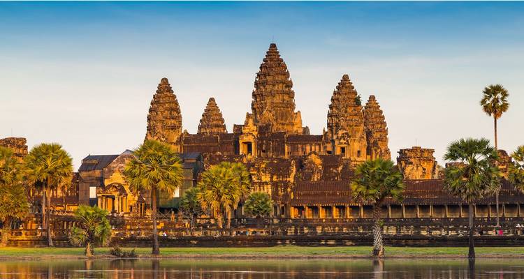 Iconische Angkor Wat tempelcomplex weerspiegeld in een rustige gracht bij zonsopgang.