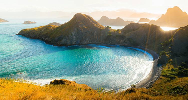 Vue aérienne spectaculaire des baies turquoise de l'île de Padar et de ses collines escarpées à la lumière de l'aube