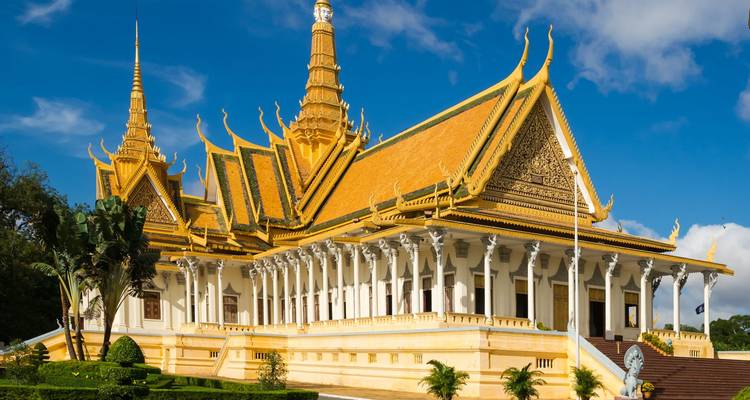 Die elegante Thronsaal des Königspalasts von Phnom Penh, geschmückt mit goldenen Spitzen, erhebt sich unter einem strahlend blauen Himmel.