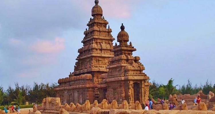 Shore temple with pillars in a sandy beach setting.