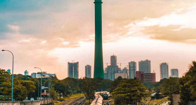 A tall tower with a city skyline in the background.