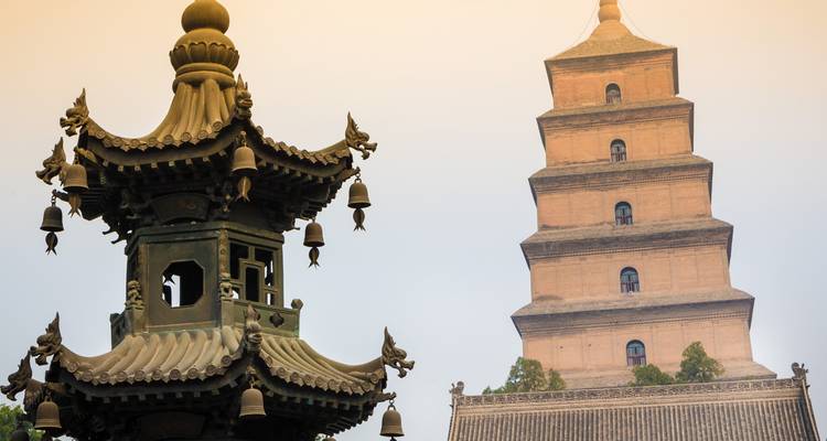 Une pagode historique aux détails complexes à côté d'un bâtiment ancien.