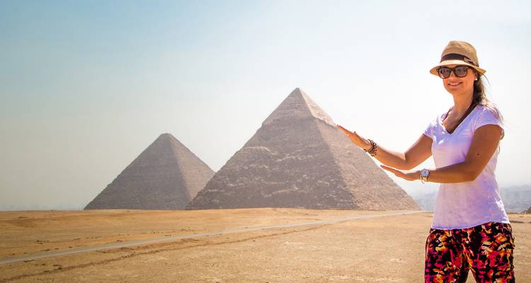 Frau posiert vor den Pyramiden von Gizeh.