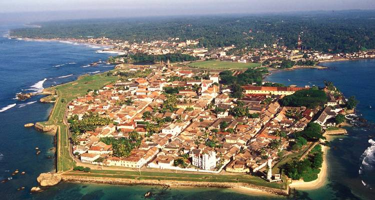 Vue aérienne d'une ville côtière avec des bâtiments historiques.