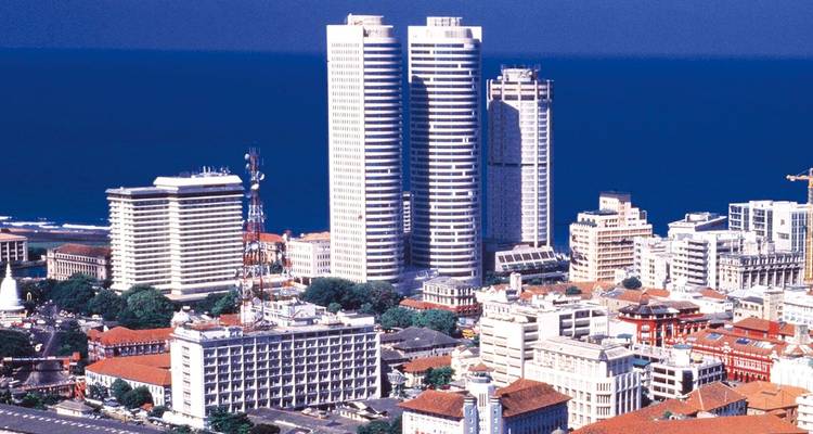 Skyline moderne de Colombo avec des tours jumelles de grande hauteur surplombant les bâtiments coloniaux de faible hauteur et l'océan Indien.
