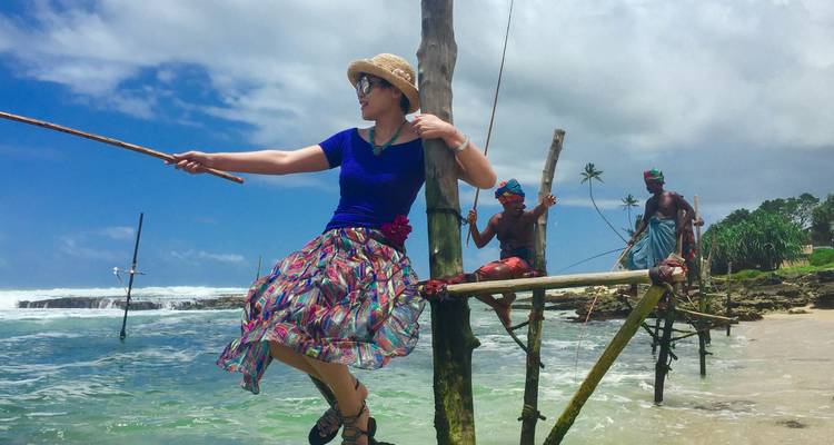 People engaged in traditional fishing on stilts at the beach.