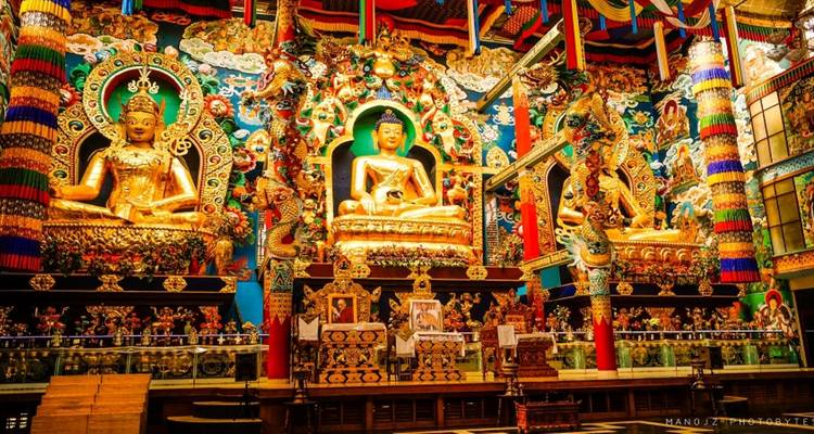 Ornate golden statues and decorations inside a colorful temple.