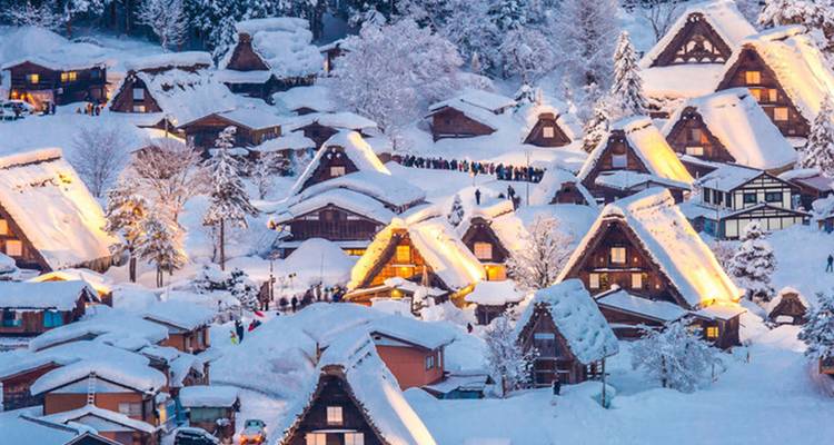 Pintoresco pueblo nevado con casas iluminadas.