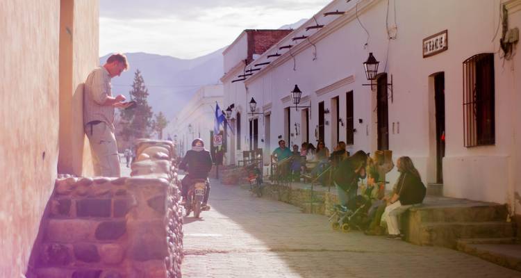 Soziale Szene auf einer historischen Straße mit Cafés und interagierenden Menschen.