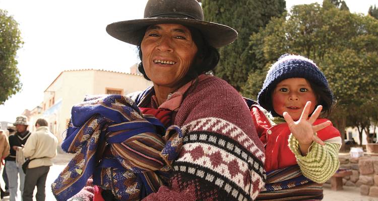 Lächelnde Frau mit einem Kind in traditioneller Kleidung.