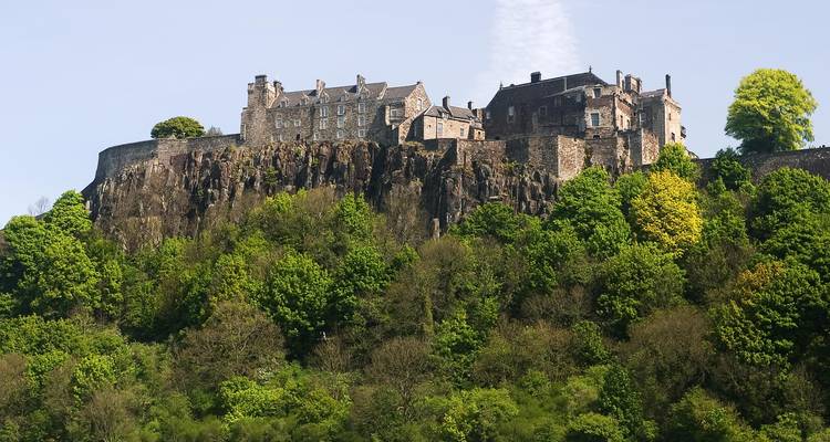 Stirling Castle thront auf einem felsigen Hügel, umgeben von Bäumen.