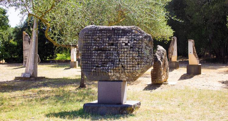 Sculptures dans un espace extérieur avec des arbres.