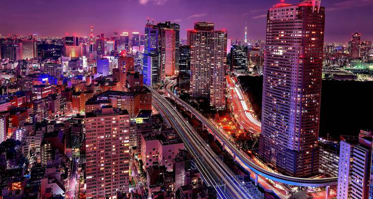Tokyo skyline at night with a view of illuminated skyscrapers.