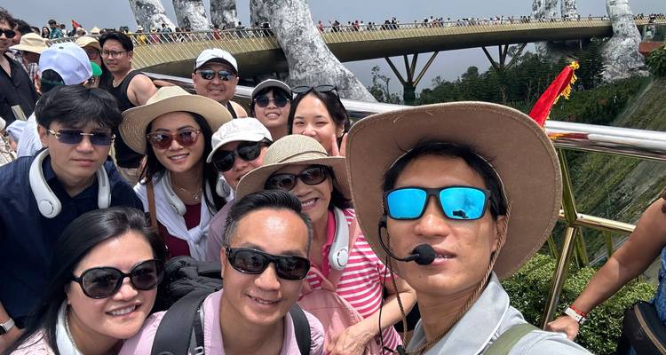 Turistas felices se toman una selfie con el famoso Puente Dorado de Vietnam y las gigantes manos de piedra en el fondo