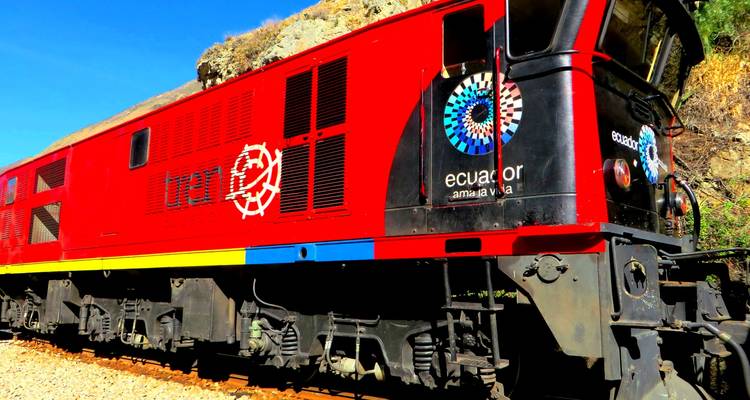 Train aux couleurs vives avec le logo 'Ecuador' sur le côté, arrêté sur les rails.