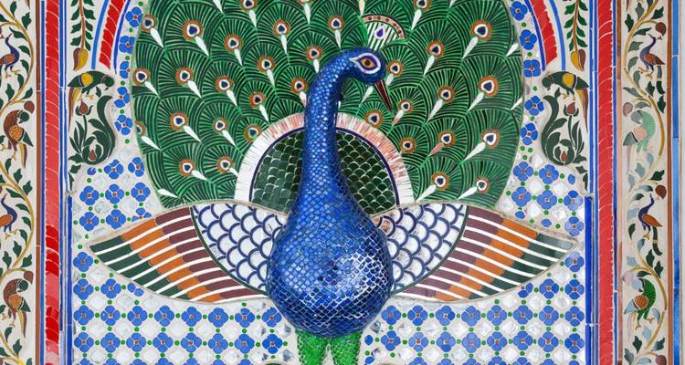 Colorful peacock mosaic artwork on a wall.