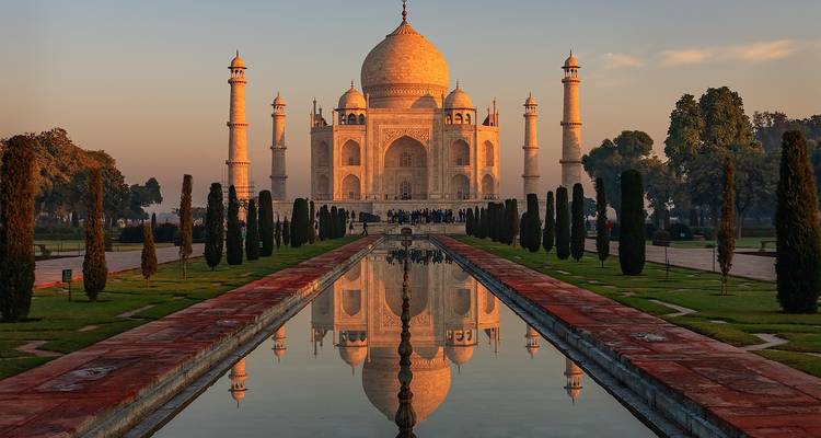 Das Taj Mahal spiegelte sich bei Morgendämmerung perfekt in einem langen rechteckigen Becken wider.