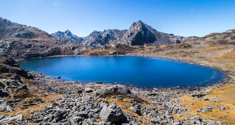 Klarer blauer See umgeben von felsigen Bergen.