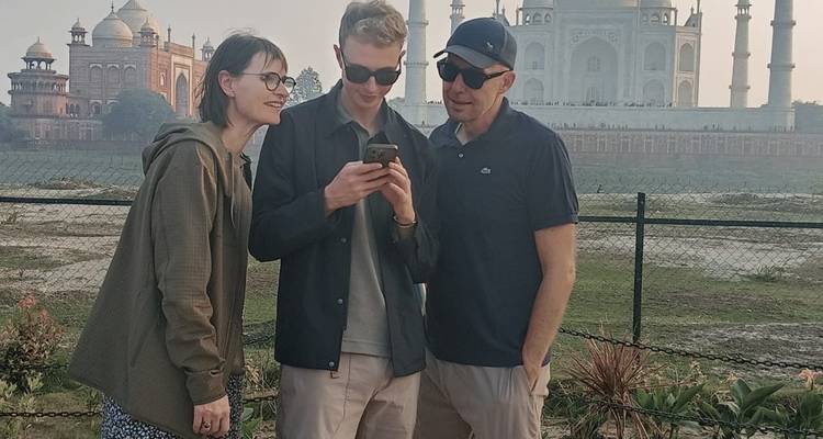 Groupe vérifiant un téléphone devant le Taj Mahal.