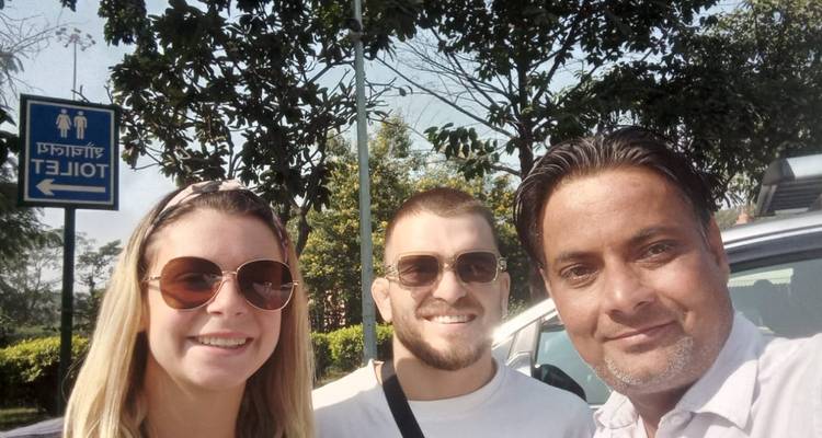 Trois personnes prenant un selfie près d'un panneau.