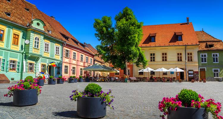 Colorful town square with flowers in large pots.