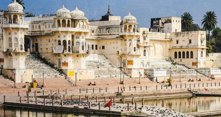 Large palace with intricate carvings and a reflecting pool.