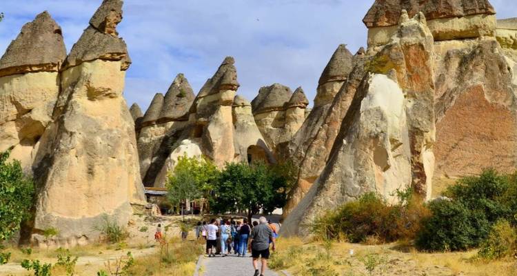 Gruppe von Touristen, die durch eine felsige Landschaft wandern.