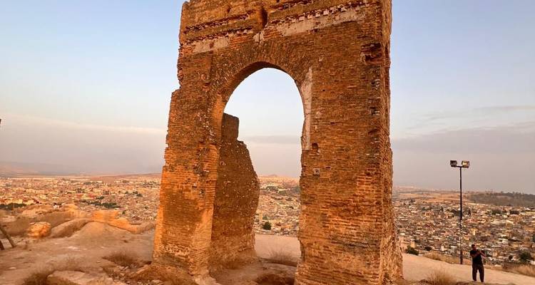 Une arche ancienne avec un paysage urbain en arrière-plan.