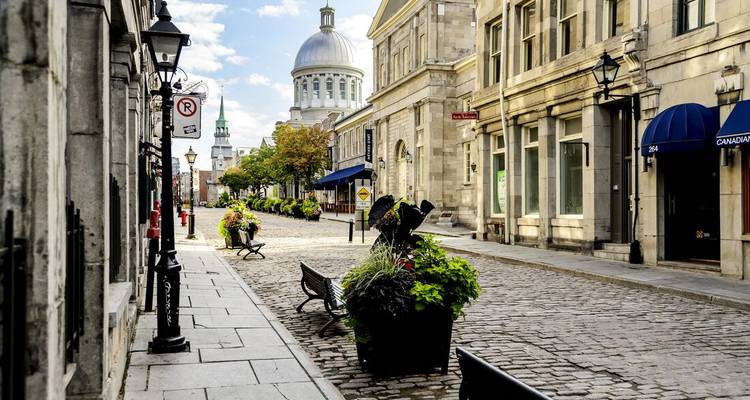 Historische straat omzoomd met oude stenen gebouwen en een koepel op de achtergrond.