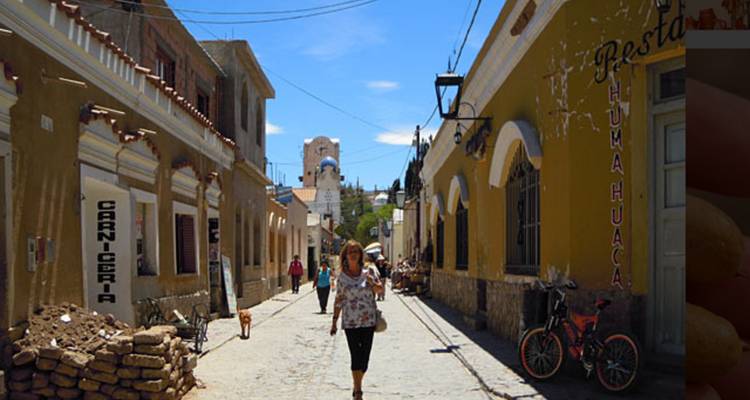 Mensen die over een levendige straat lopen met koloniale architectuur.