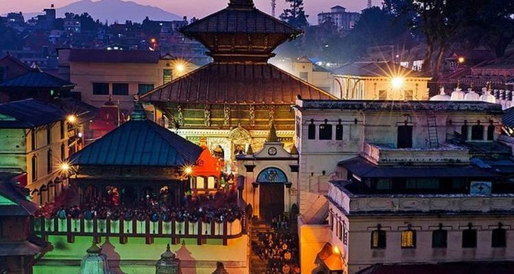 Pashupatinath Temple at dusk with people.