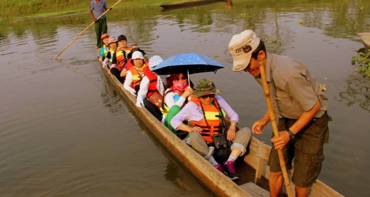 Group of tourists on a canoe ride on a river, guided by a local man.