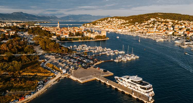 Aerial view of a coastal city with yachts and piers.