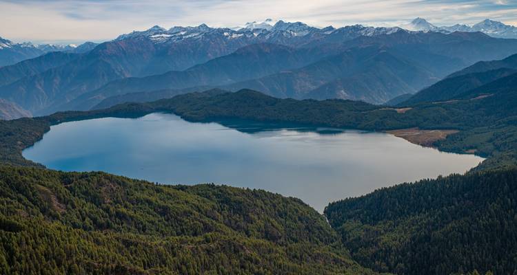 Mountain lake with surrounding snow-topped hills.
