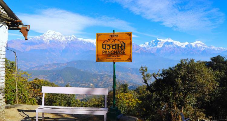 A sign for Panchase with Himalayan mountains in the background.