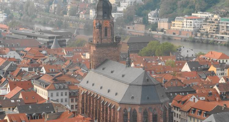 Vue aérienne d'une église avec des toits de tuiles rouges qui l'entourent.