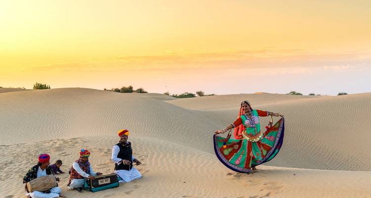 Traditional Rajasthani performance in the desert at sunset.