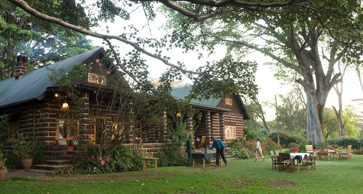 Charmant cottage avec des tables dressées à l'extérieur.