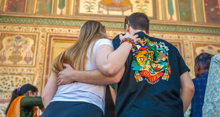Couple admirant des peintures murales à l'intérieur d'un site historique.