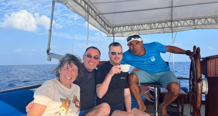 Groupe de personnes assises sur un bateau, savourant un verre.