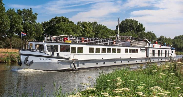 River boat cruise with scenic green surroundings.