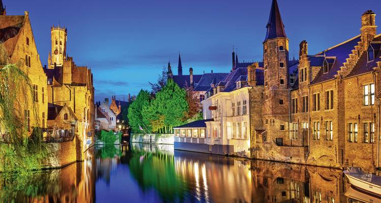Canal scene with illuminated historic buildings at night.