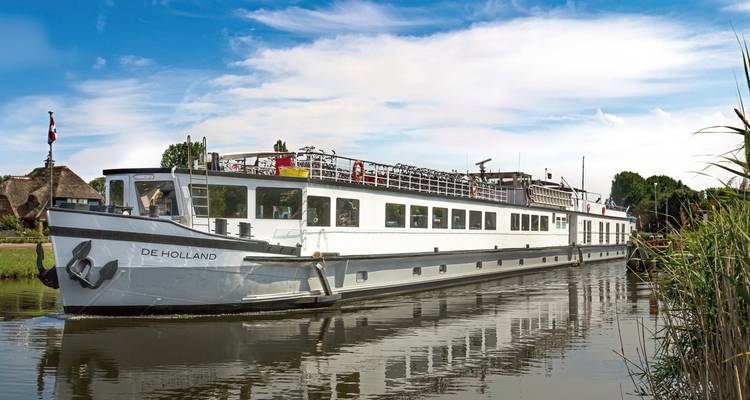 Langes Kreuzfahrtschiff 'De Holland' in einem ruhigen Kanal.