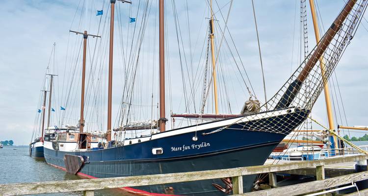 Angedocktes Schiff mit mehreren Masten und klarem blauen Himmel