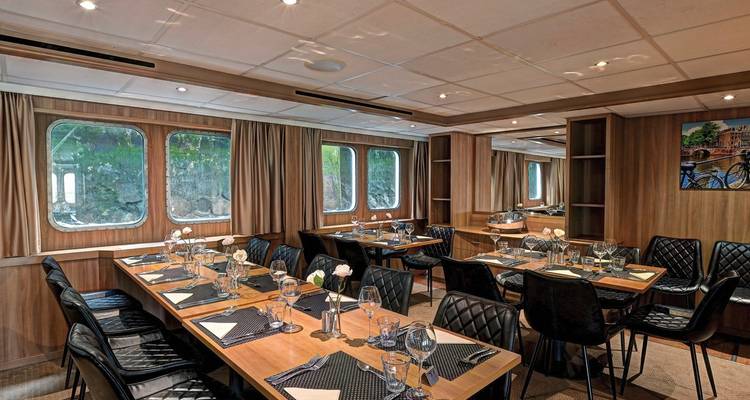 Esszimmer-Interieur mit gedeckten Tischen für eine Mahlzeit.